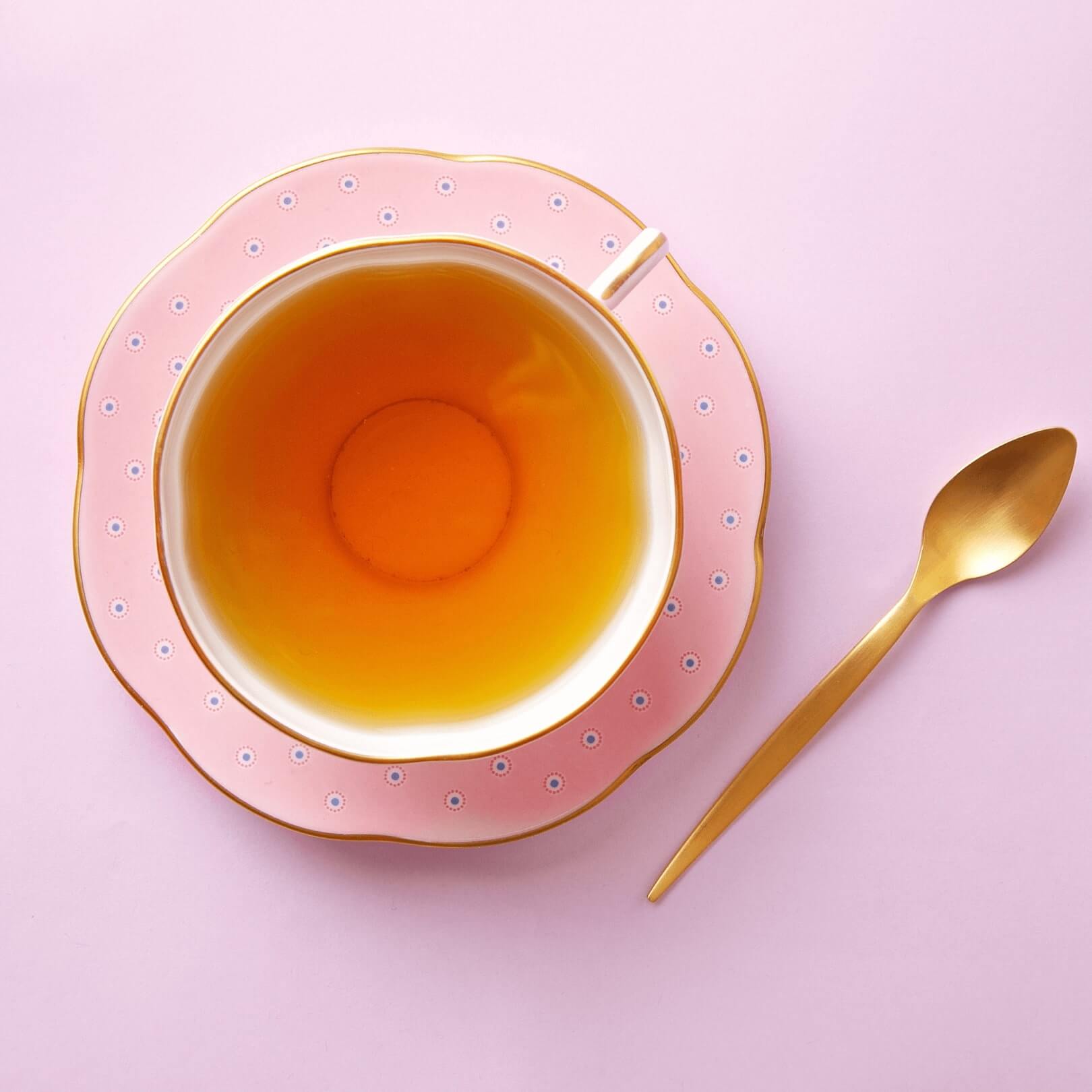 pink teacup with golden spoon